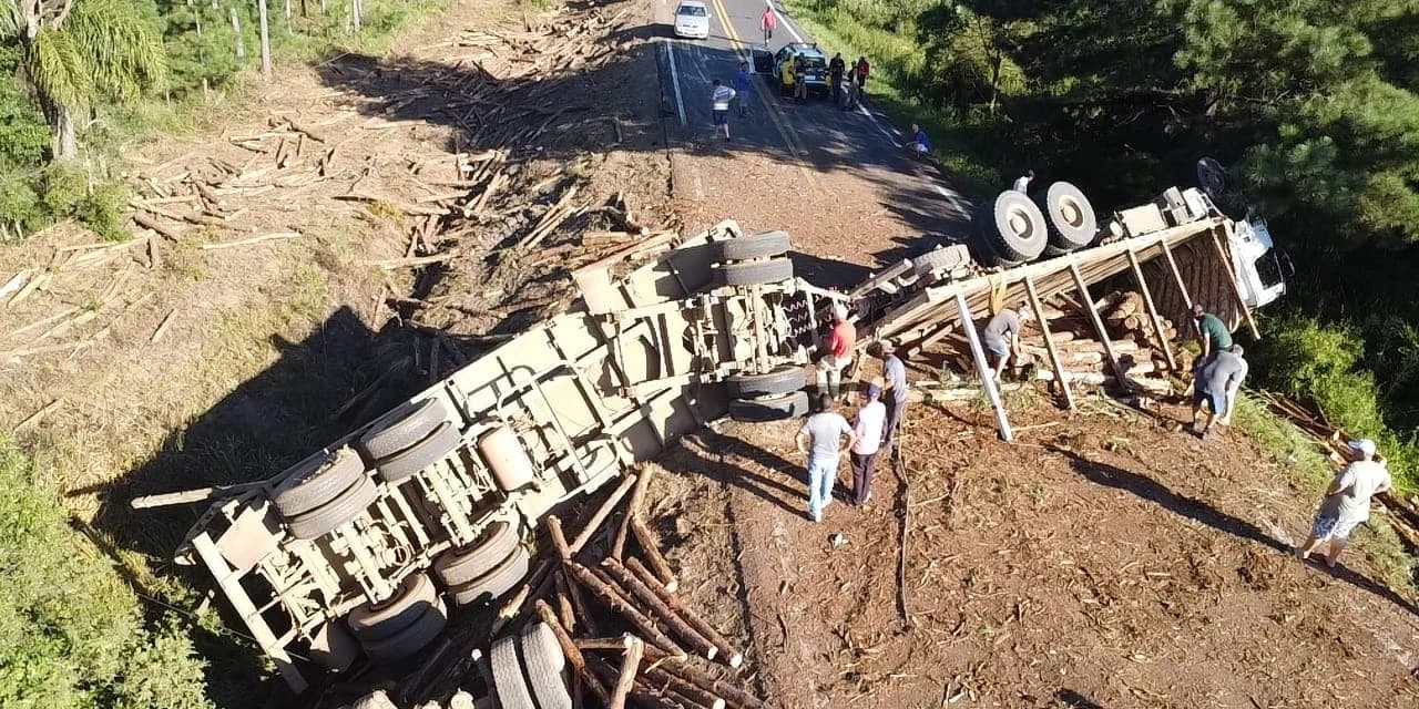 Caminhão carregado com toras de pinus tomba na BR-153 e interdita pista em Mallet